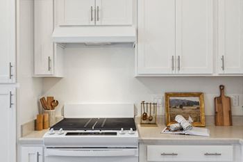 a white kitchen with white cabinets and a white stove